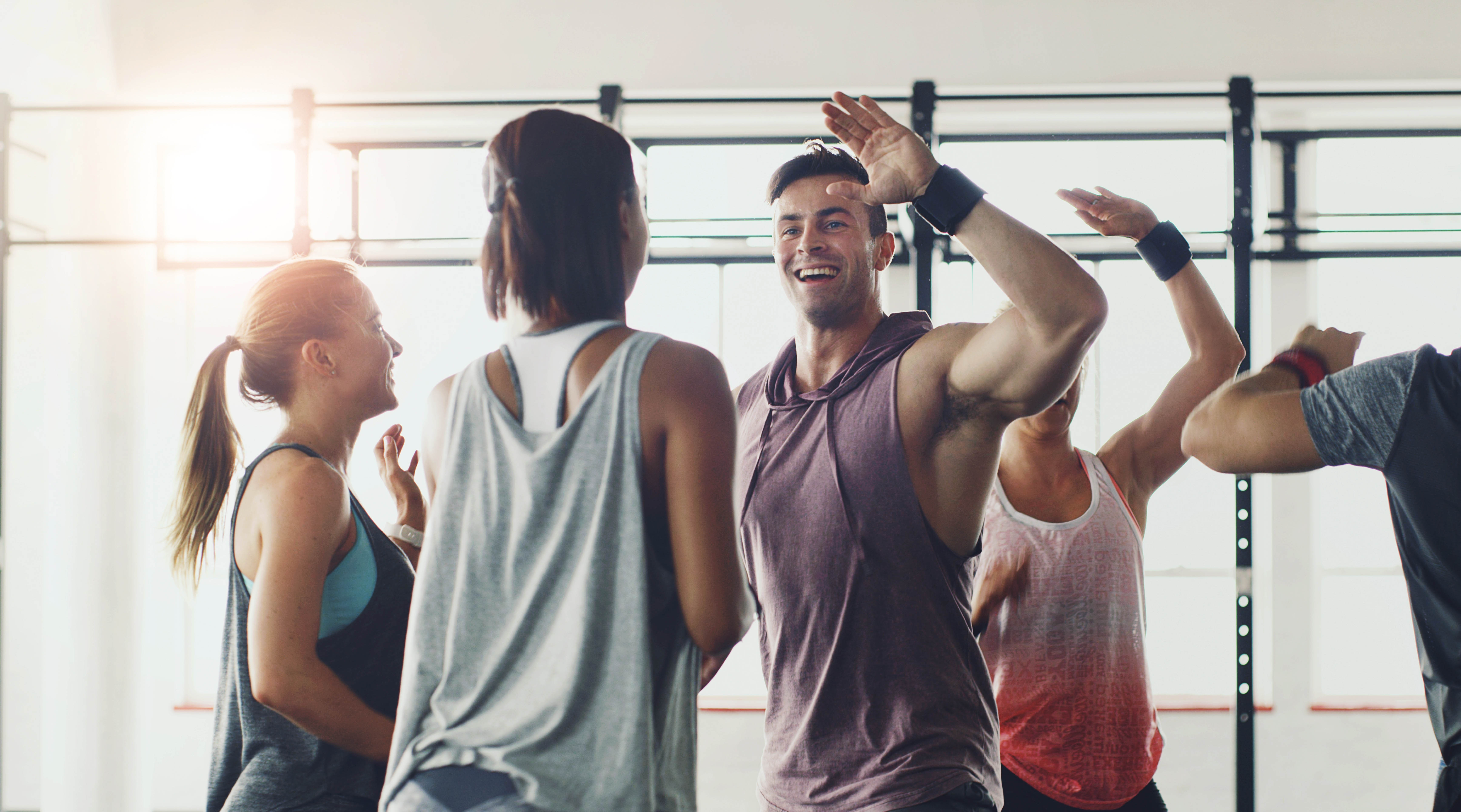 Small group in the gym giving high fives to each other Small group in the gym giving high fives to each other